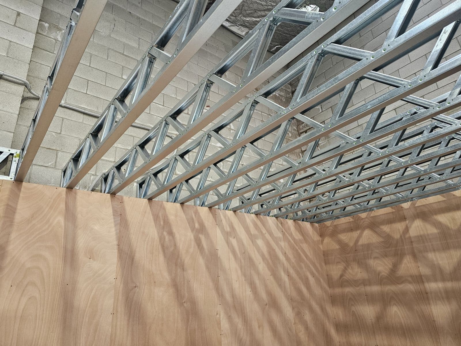 Light gauge steel mezzanine floor joists spanning a warehouse with block walls